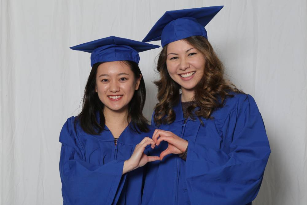 two girls pose with heart
